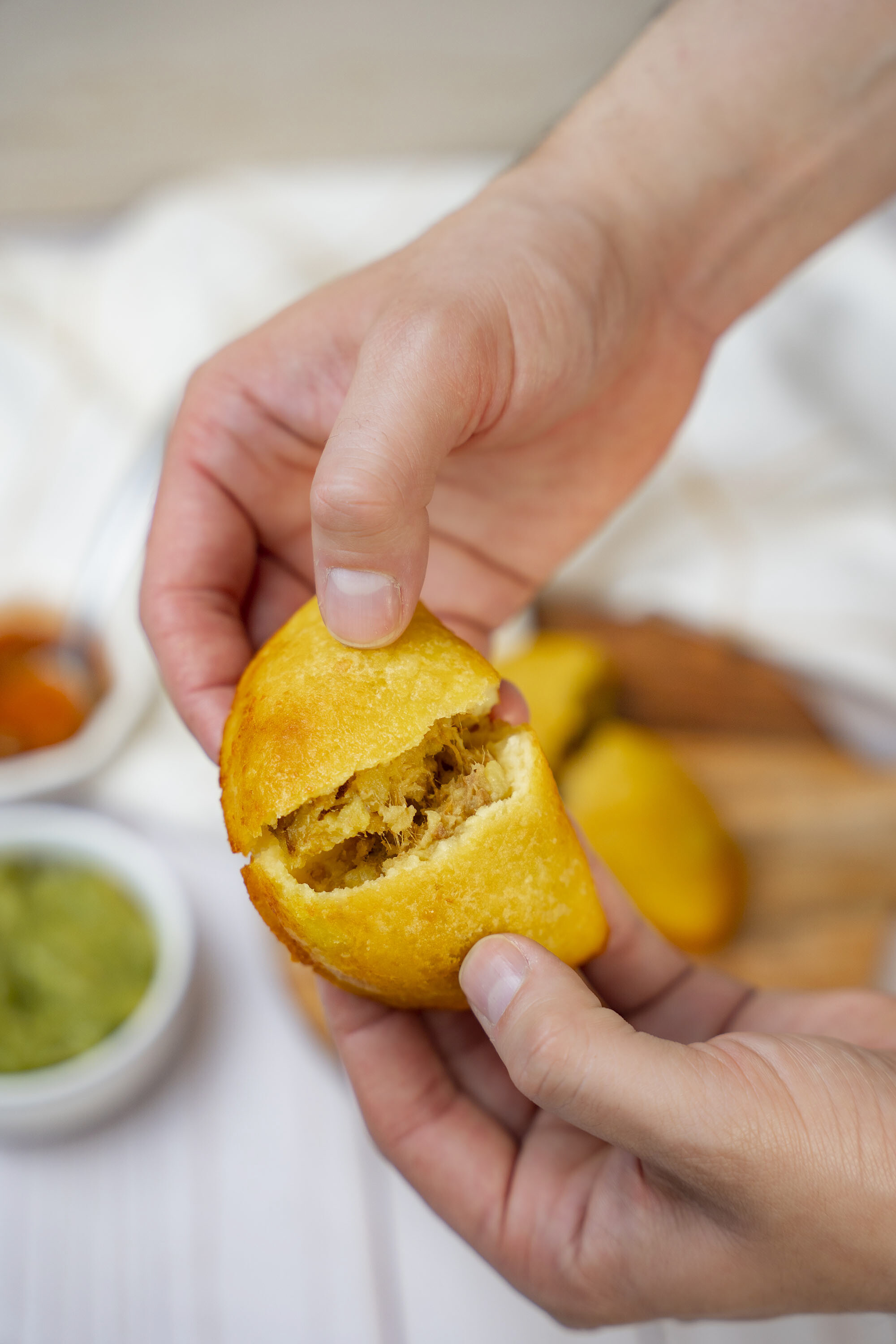 Hand-held empanada showing meat filling